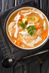 Canja de galinha recipe is a classic chicken and rice soup close up in the plate on the table. Vertical top view from above