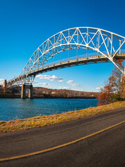 Wall Mural - Sagamore Bridge and paved bikeways along the Cape Cod Canal. Peaceful and safe outdoor recreational park in Bourne, Massachusetts. Arching landmark metal bridge connecting Massachusetts mainland to Ca