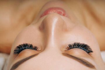 Wall Mural - Eyelash Extension Procedure. Woman Eye with Long Eyelashes. Close up, selective focus.