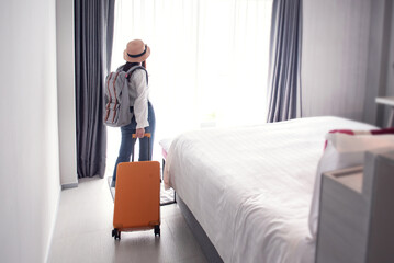 Tourist woman with luggage in hotel after check-in. Conceptual of travel and vacation.