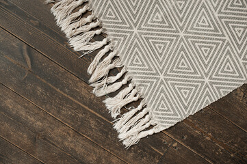 grey smooth rug with geometric shapes on stylish dark wooden parquet. scandinavian style home accessories. selective focus