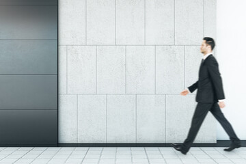 Aufkleber - Businessman walking in abstract interior with empty mock up place on concrete tile wall and floor. Exhibition and art concept.