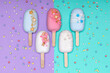 top view of decorated cake pops ice creams on violet and turquoise background
