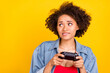 © deagreez - Photo of young happy dark skin cheerful woman look empty space doubt hold joystick isolated on yellow color background