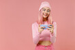 © ViDi Studio - Young gambling fun woman with dyed rose hair in rosy top shirt hat using play racing app on mobile cell phone hold gadget smartphone for pc video games isolated on plain light pastel pink background.
