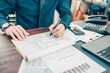 © Charnchai saeheng - A man hand planning daily appointment and note at office desk. Planner plan Schedule Calendar and reminder. Business planning appointment concept.