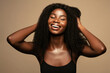 Overjoyed. Beauty fashion portrait of happy young beautiful african american woman with volume,curly hair against beige background