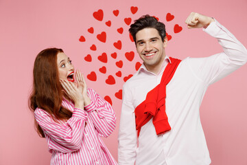 Poster - Young amazed couple two friends woman man in casual shirt showing biceps muscles on hand demonstrating strength power isolated on plain pink background. Valentine's Day birthday holiday party concept.