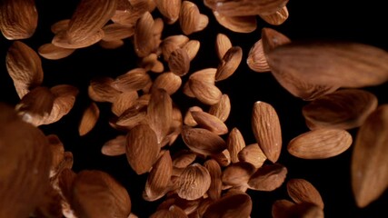Poster - Super slow motion of falling almonds pieces, wide super macro shot. Isolated on black background. Filmed on high speed cinema camera, 1000fps.