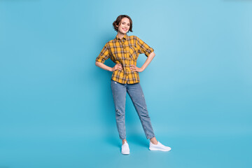 Poster - Photo of cheerful pretty lady hands hips wear checkered shirt jeans sneakers isolated blue color background