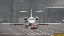 Slow-motion Video As An Escort Car At The Airport Leads A Private Small Plane On The Runway.