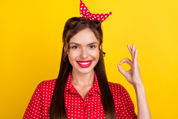 Wall Mural - Photo portrait woman in red outfit showing okay gesture isolated bright yellow color background