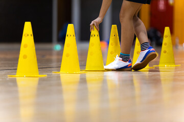 Row of Yellow Training Cones at Indoor Practice Field. Young Player on Training With Practice Trail. Physical Education Class For Youths