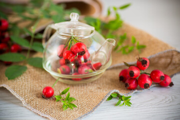 Wall Mural - ripe red rose hips on a wooden table