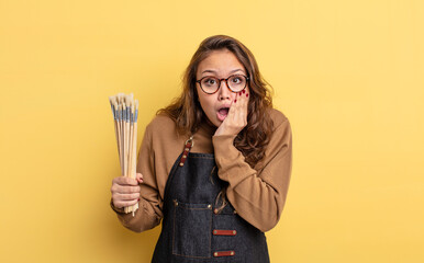 Wall Mural - hispanic pretty woman feeling shocked and scared. artist with brushes concept