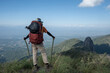 A trekker carried a backpack with a black trash bag hung from the top of the mountain.