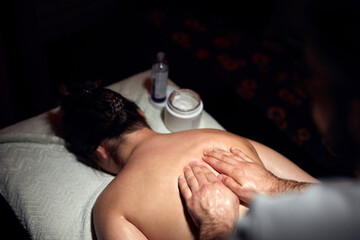 Woman on a massaging, chiropracting table, treatment of body and skin tension.