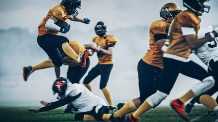 Wall Mural - American Football Field Two Teams Compete: Successful Player Jumping Over Defense Running to Score Touchdown Points. Professional Athletes Compete for the Ball, Tackle, Fight for Championship Victory