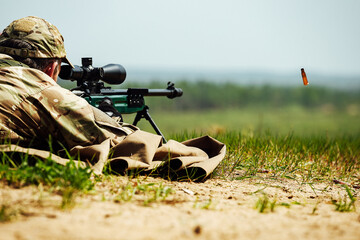 a sniper shoots lying down with a rifle with an optical sight