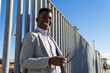 © ADDICTIVE STOCK - Black man in formal suit near fence
