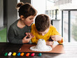 © ADDICTIVE STOCK - Concentrated kids molding plasticine while creating volcano figurine