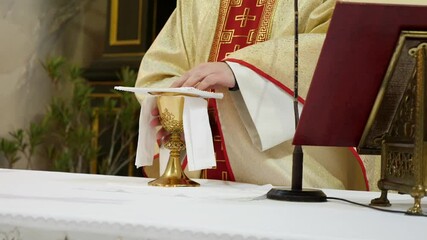 Wall Mural - The priest makes objects and a chalice intended for the holy communion.