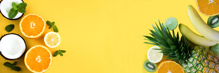 Wall Mural - Tropical fruits on the yellow background. Banner. Copy space. Top view.