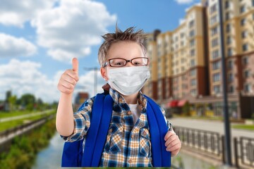 Poster - Young child in mask and a uniform with a backpack outdoors. Back to school.