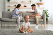 © Prostock-studio - Family Conflicts. Little Baby Boy Sitting Alone While Parents Quarreling On Background