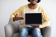 © Prostock-studio - Black Man Holding And Pointing At Laptop With Blank Screen, Mockup