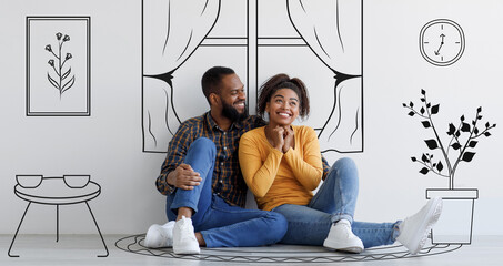 Cheerful black couple planning and imagining new house interior