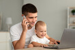 © Prostock-studio - Handsome Young Father Talking On Cellphone While Baby Using Laptop At Home