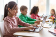 © Prostock-studio - Diverse Children Learning Using Laptop In Modern Classroom At School