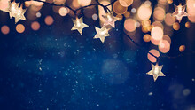 Star Shaped Christmas String Lights On Blue Night Background With Golden Bokeh Lights
