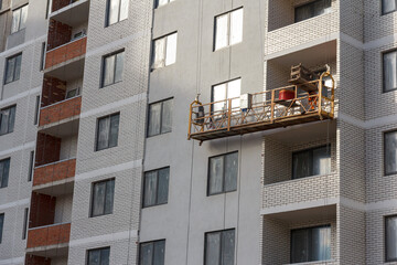 Poster - Finishing the facade of an apartment building under construction. Construction of a new house.