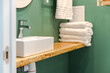 Bathroom in an apartment for rent or a hotel, close-up of a sink and a stack of fresh white towels