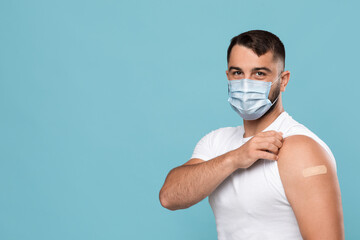 Serious mature caucasian man in protective mask shows hand with plaster after vaccination