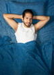 © Narayan - young latin man sleeping blue color bed, rest concept
