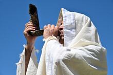 Orthodox Jewish Man Blow Shofar (ram's Horn) Outdoors Under Clear Blue Sky, On The Jewish High Holidays In Rosh Hashanah And Yom Kippur.
