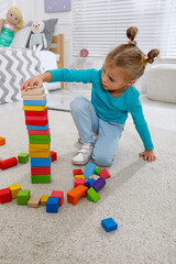 Sticker - Cute little girl playing with colorful building blocks at home