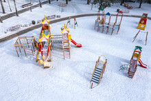 Frozen Colorful Playground Under Snow In Winter Park At Sunny Winter Morning. Aerial View With Drone.