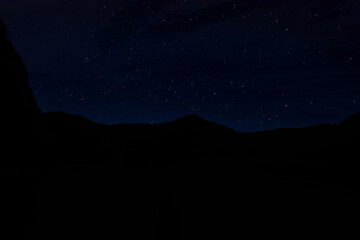 Wall Mural - Beautiful view of starry sky over mountains at night