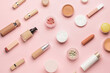 Different decorative cosmetics and clean cotton pads on pink background