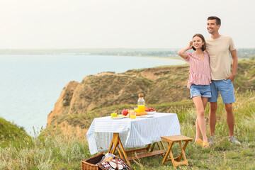 Canvas Print - Happy young couple having romantic picnic in mountains