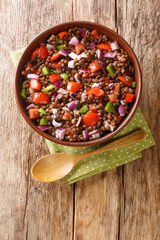 Canvas Print - Azifa is an Ethiopian green lentil dish with lime juice, tomato, mild hot peppers, onion and spices close up in the plate on the table. Vertical top view from above