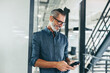 © Jacob Lund - Cheerful businessman sending a text message in an office