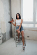© kalinichenkod - beautiful girl in overalls with electric drill