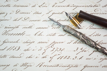 Top close-up view of two different penholders over a hand lettering sample