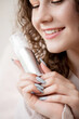 © Parilov - Concept of care for skin face and structure of hair young woman, closeup smile and bottle with liquid bubble product