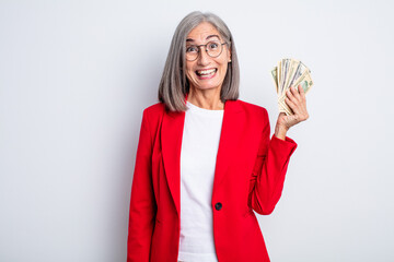 Wall Mural - senior pretty woman looking happy and pleasantly surprised. business and banknotes concept